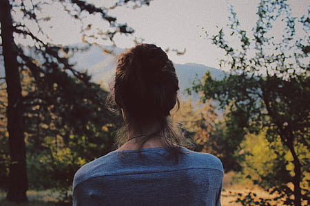 woman wearing blue top near tree during daytime thumbnail