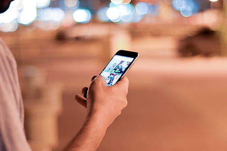 Man Holding and Scrolling a Black Smartphone thumbnail