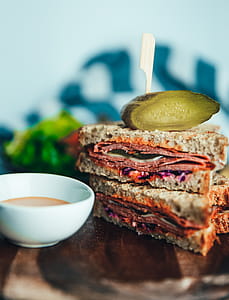 Close-up of salami sandwich with sauce on the table thumbnail