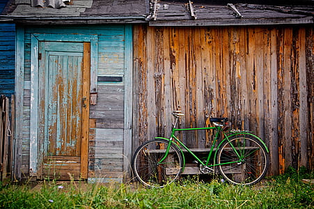 photo of green bike near brown wooden house thumbnail