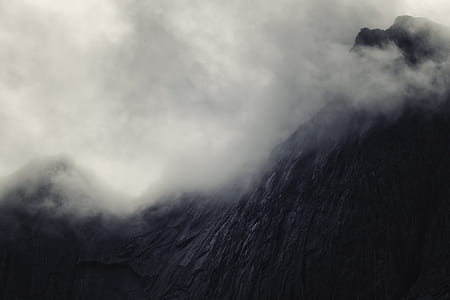 low angle photography of black fogging mountain thumbnail
