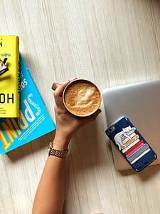 Person Holding a Cup Filled With Cappuccino thumbnail