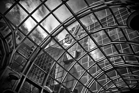 grayscale photo of building under cloudy sky thumbnail