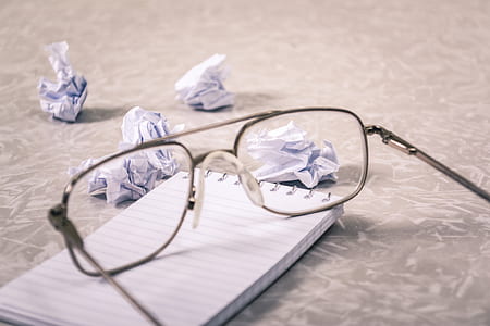 clear eyeglasses with black frames on white notebook thumbnail