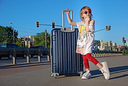 girl holding hardside luggage bag thumbnail