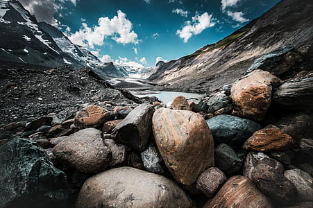 brown and gray stones near mountain under blue sky at daytime thumbnail