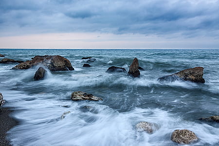 long exposure photography of water waves and stones at daytime thumbnail