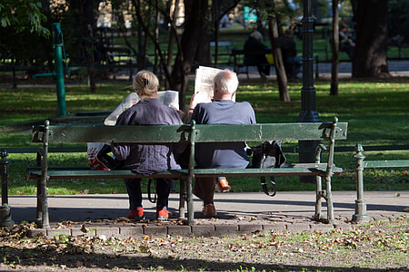 man and woman sitting on green wooden bench seat during daytime thumbnail