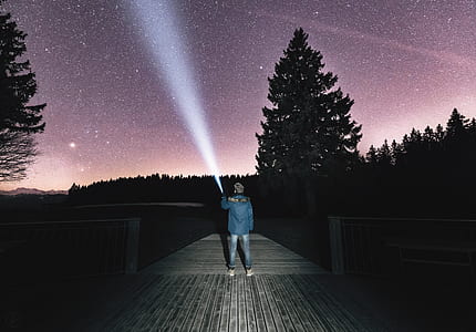 boy standing on boat dock using flashlight thumbnail