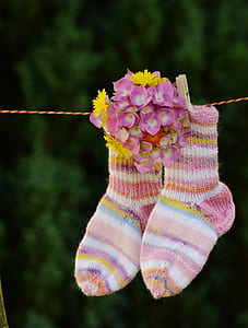 shallow focus photo of pair of multicolored socks hanging on red and yellow rope thumbnail