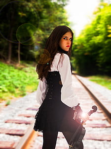 woman holding violin standing on railway thumbnail