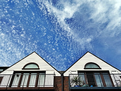 white snow falling on white painted wooden house thumbnail