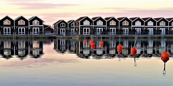 white and black wooden village near body of water thumbnail