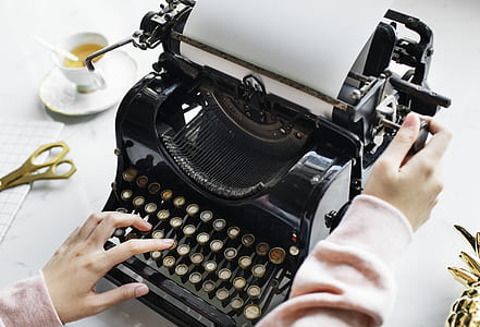 woman holding black typewriter thumbnail