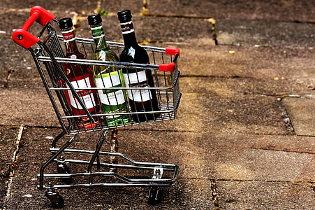 three labeled bottles in shopping cart on street thumbnail