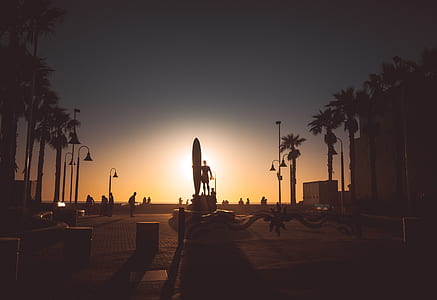 person holding surf board statue thumbnail