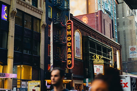 people walking along the road beside buildings thumbnail
