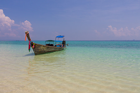 brown canoe in ocean water during daytime thumbnail
