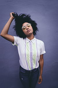 woman holding her hair near blue concrete wall thumbnail