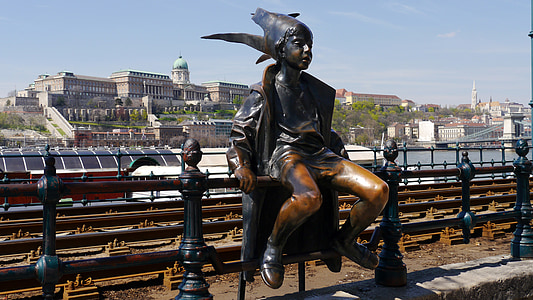 boy sitting on railing statue at daytime thumbnail