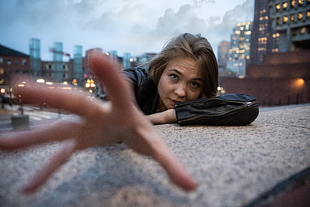 person wearing black leather jacket leaning on gray concrete surface during daytime thumbnail