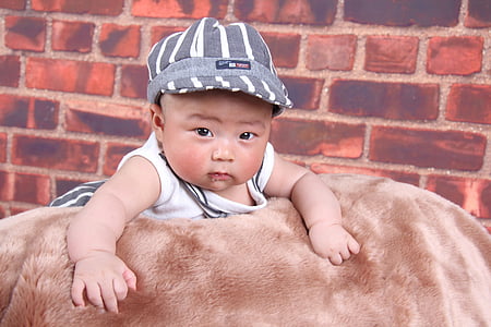 baby lying on beige blanket indoor thumbnail