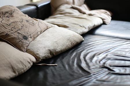 square beige throw pillows on black bed thumbnail