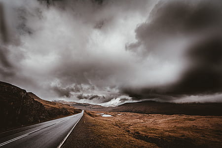 empty gray concrete road top surrounded with brown mountains undergray clouds during daytime thumbnail