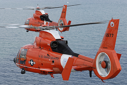 two red helicopters over body of water during daytime thumbnail