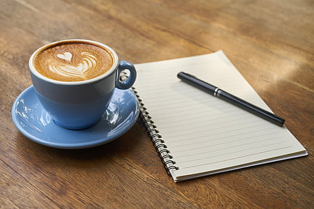 cup of espresso on saucer beside spiral note thumbnail