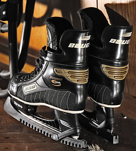 pair of black Bauer ice hockey skates on brown wooden surface thumbnail