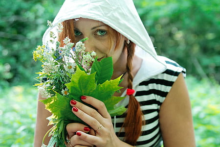 woman sniffing flowers outdoor during daytime thumbnail