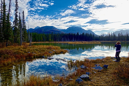person standing on brown grass near body of water during dayttime thumbnail