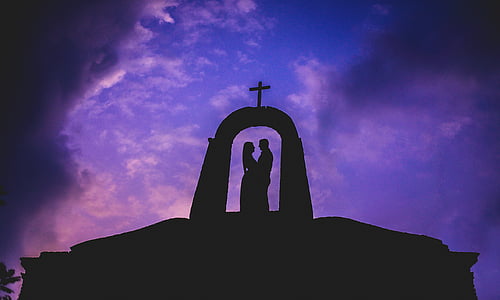 silhouette of man and woman under arch cross thumbnail