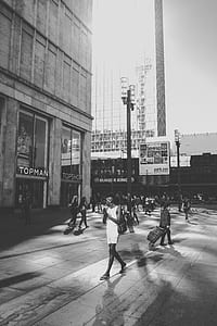 grayscale photography people walking under building thumbnail