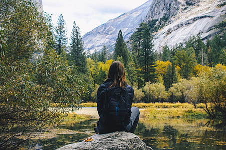 woman sitting on rock in front of mountain thumbnail