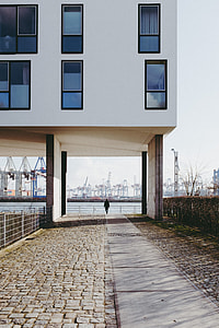 Man walking in front of the port of Hamburg thumbnail