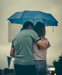 Man Hugging Woman while Holding Umbrella thumbnail
