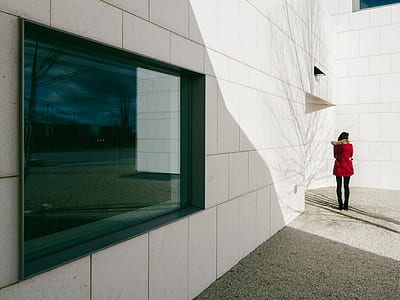 woman standing near white wall thumbnail
