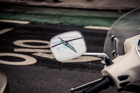 motorcycle side mirror showing green signage thumbnail