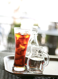 clear hurricane glass beside pitcher on tray thumbnail