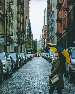 woman in green coat holding umbrella on street during daytime thumbnail