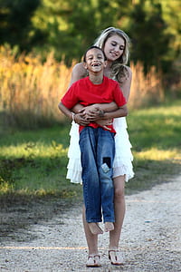 woman carrying toddler boy walking on road at daytime thumbnail
