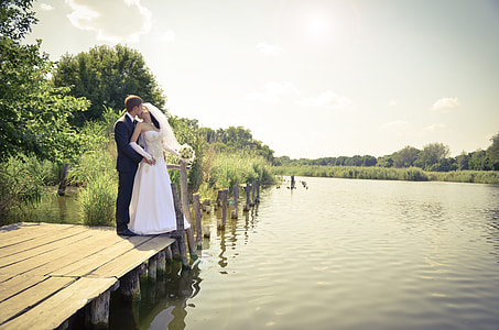 bride and groom standing on dock during daytime thumbnail