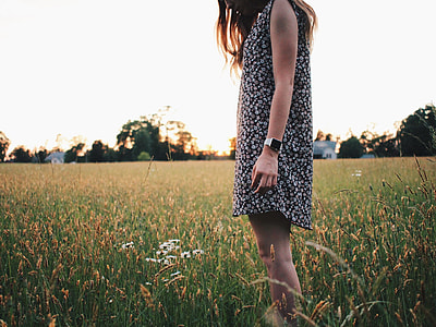 woman in floral shift dress standing on wheat fields thumbnail