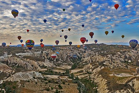 assorted color hot air balloons flying over countryside thumbnail
