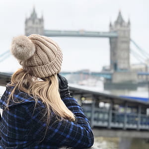 Woman Wearing Brown Beanie Holding Smartphone thumbnail