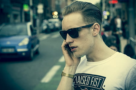 focus photography of man taking call from black smartphone outdoor near street thumbnail