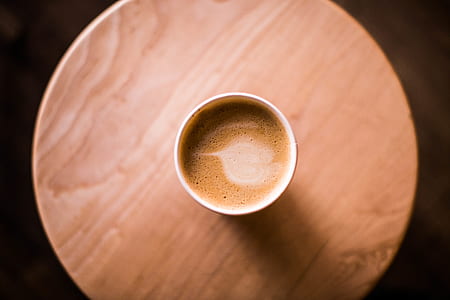 coffee filled cup on round brown table thumbnail