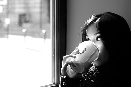 grayscale photography of woman drinking coffee near the mirror thumbnail